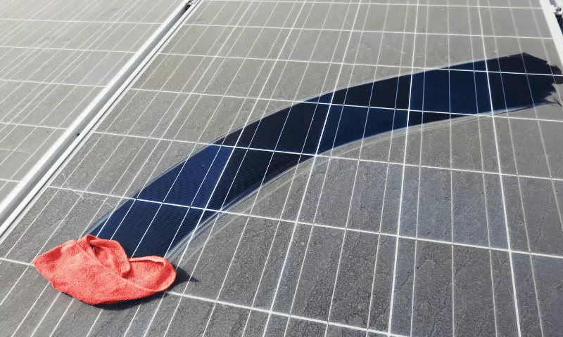 dirty solar panel being wiped clean